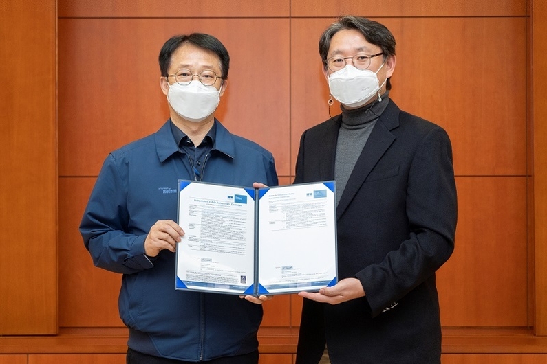 왼쪽부터 김종년 현대로템 레일솔루션연구소장과 신석균 리카르도 레일 동아시아 대표가 진접선 전동차 독립안전성평가 인증서를 들고 기념 촬영을 하고 있다 (출처: 현대로템)