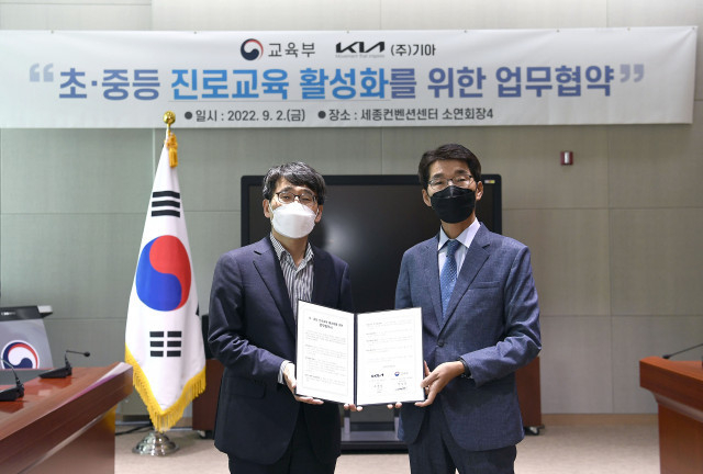 왼쪽부터 나주범 교육부 차관보와 권혁호 기아 국내 사업본부장이 업무협약을 체결하고 기념 촬영을 하고 있다. (출처 : 기아)