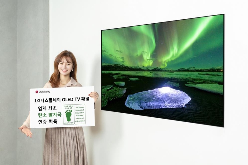 사진은 LG디스플레이 모델이 카본 트러스트 인증서와 OLED TV 패널을 소개하는 모습. (출처: LG디스플레이)