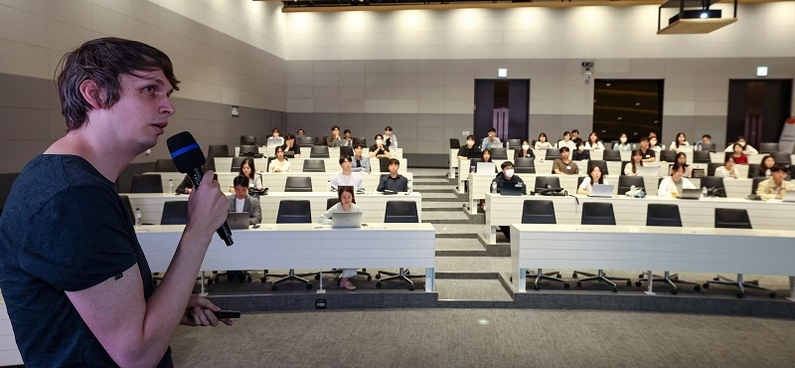 LG AI연구원의 폴 베르턴스 연구원이 지난 22일 서울 마곡 LG사이언스파크에서 열린 LG 에이머스 멘토링 데이에서 해커톤 경험을 주제로 강연하고 있다.(출처: LG)