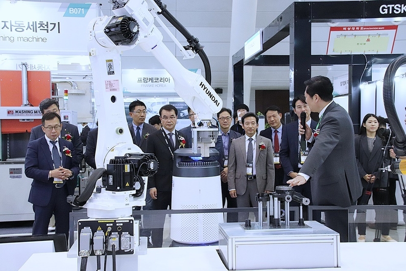 SMATOF 2023 관계 내빈이 HD현대로보틱스 전시부스를 방문해 로봇 솔루션에 대한 관계자의 설명을 청취하고 있다. (출처 : 헬로티)
