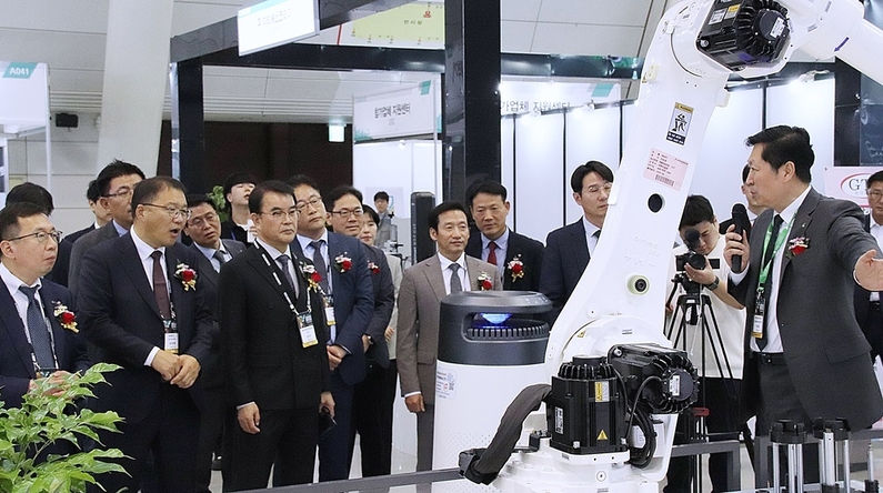 SMATOF 2023 관계 내빈이 HD현대로보틱스 전시부스를 방문해 로봇 솔루션에 대한 관계자의 설명을 청취하고 있다. (출처 : 헬로티)