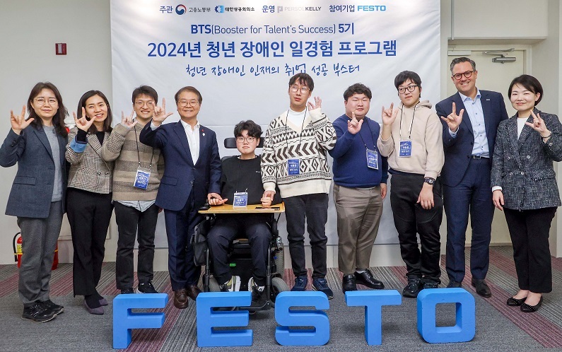 한국훼스토 청년 장애인 일경험 프로그램 5기 수료자들과 이정식 고용노동부 장관(좌측에서 네 번째), 한국훼스토 대표이사 토마스 레킥(우측에서 두 번째)이 ‘사랑합니다’를 의미하는 수어와 함께 기념촬영을 진행하고 있다. (제공: 한국훼스토)