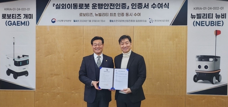 손웅희 한국로봇산업진흥원장(좌)과 김병수 로보티즈 대표(우)가 실외이동로봇 운행안전인증 인증서 수여식에서 기념촬영 중이다. (출처 : 로보티즈)