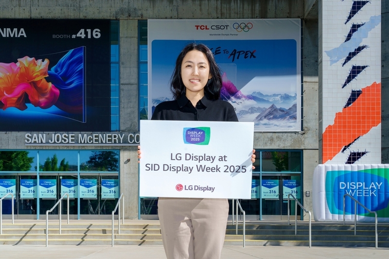 LG디스플레이 직원이 ‘SID 2025’가 열리는 미국 새너제이 맥에너리컨벤션센터 앞에서 참가 소식을 알리고 있다. (출처 : LG디스플레이)