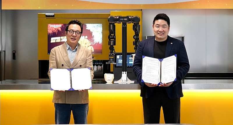 엑스와이지가 식음료(F&B) 무인·자동화 구현을 위해 속도를 낸다. 맘스터치앤컴퍼니와의 파트너십을 통해 활동 영역을 확장하고 있다. 사진은 김동전 맘스터치앤컴퍼니 대표이사(좌)와 황성재 엑스와이지 대표이사(우)가 협력 의지를 다지고 있다. (출처 : 엑스와이지)